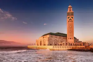 Hassan II Mosque and its minaret on the Casablanca coastline at sunset