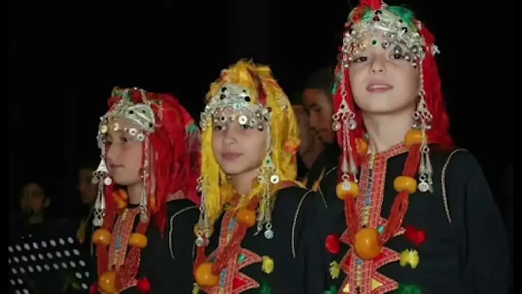 Amazigh women in traditional headdresses and silver jewellery at a night performance