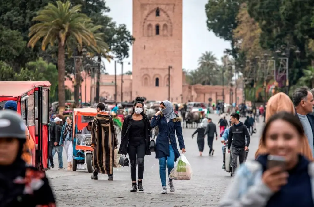 Pedestrians on a busy street beside the Koutoubia mosque in Marrakech