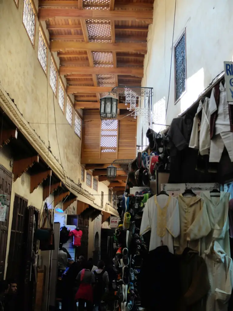Clothes and goods hanging in a covered souk lane in the Meknes medina