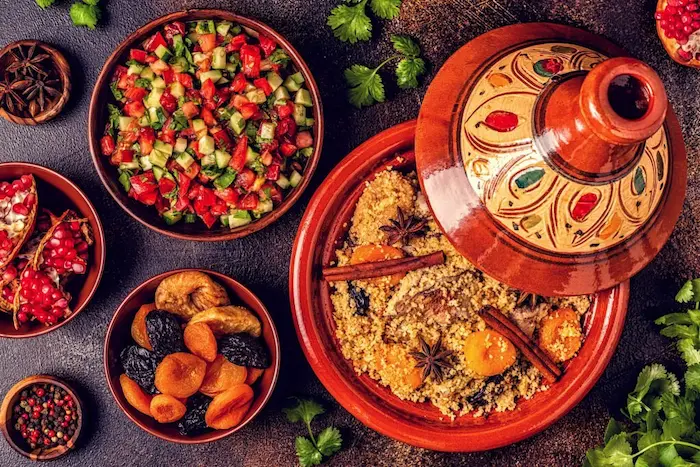 Moroccan tagine, couscous and salads served in traditional red dishes